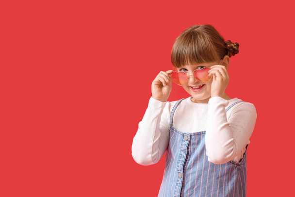 Cute little girl wearing stylish sunglasses against color background - Φωτογραφία, εικόνα