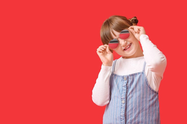 Renkli arka planda şık güneş gözlüğü takan sevimli küçük kız. - Fotoğraf, Görsel