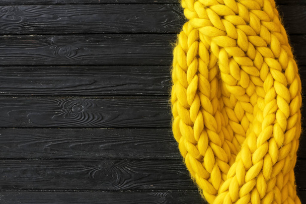 Yellow knitted plaid on dark wooden background - Foto, Imagem
