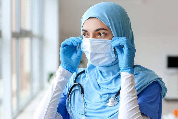 Portrait of female Muslim doctor wearing protective mask in clinic - Fotoğraf, Görsel