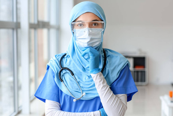Portrait of female Muslim doctor wearing protective uniform in clinic - Foto, immagini