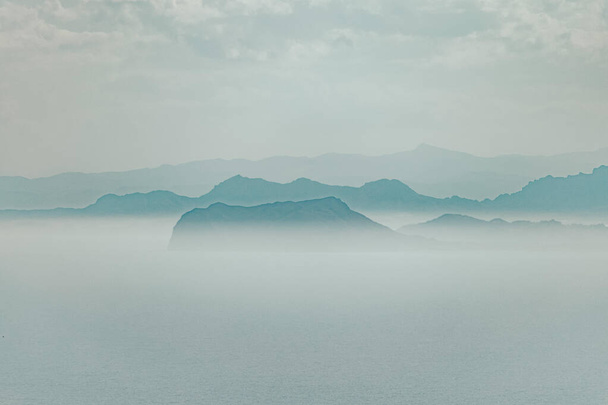 The peaks of mountains on a foggy day - Foto, afbeelding