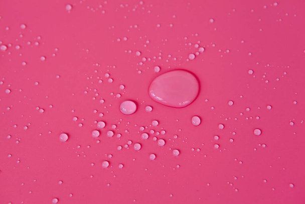 Marco completo de las texturas formadas por las burbujas y gotas de agua. Gotas de agua derramadas sobre una superficie rosa clara - Foto, Imagen