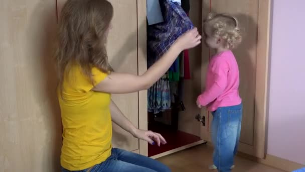 μητέρα και κόρη επιλέγουν φούστα από πολλές στην ντουλάπα. 4K - Πλάνα, βίντεο