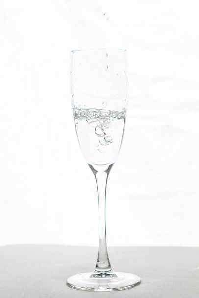 Filling up the champagne glass water  isolated on a white background - Photo, Image
