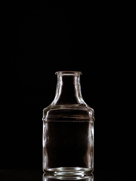 A vertical shot of an empty decanter isolated on a black background - Photo, image