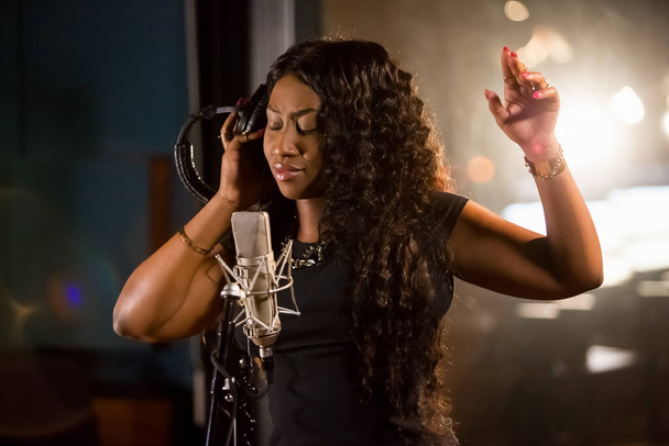 Johannesburg, South Africa - April 29, 2015: Victoria Kimani, Kenya singer recording vocal part on Afro-pop song in studio - Foto, Imagen