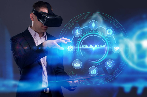Business, Technology, Internet and network concept. Young businessman working on a virtual screen of the future and sees the inscription: Industry 4.0 - 写真・画像