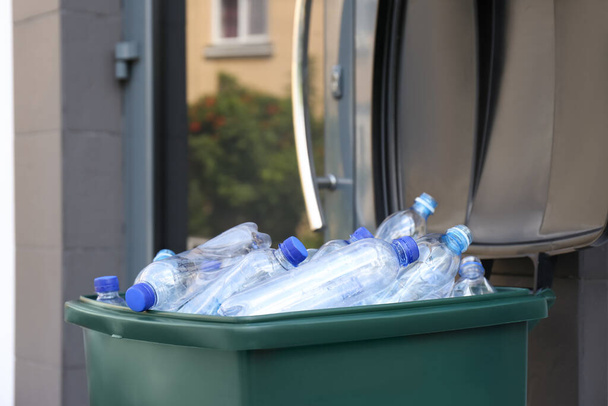 Many used plastic bottles in trash bin outdoors, closeup. Recycling problem - Foto, Imagem
