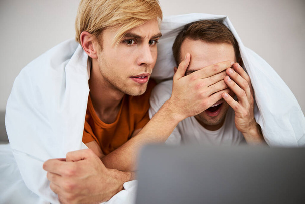 Красива гей пара дивиться страшний фільм на ноутбуці
 - Фото, зображення