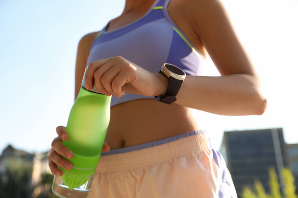 Woman with fitness tracker after training outdoors, closeup - Fotografie, Obrázek