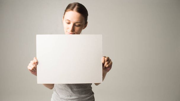 woman holding a sheet of paper in her hand - Foto, Imagen