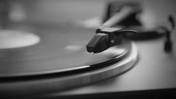 Black and White. Hand turns on a vintage vinyl record. The needle rises from a vintage vinyl record. The vinyl record is spinning. The needle plays on a vintage vinyl record. Old turntable - Footage, Video