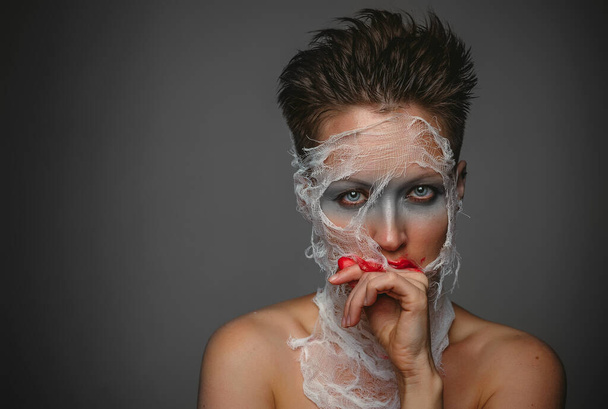 Fessel-Porträt, Frauen mit Maske im Gesicht, Horror, High Fashion, Blut, Verband - Foto, Bild