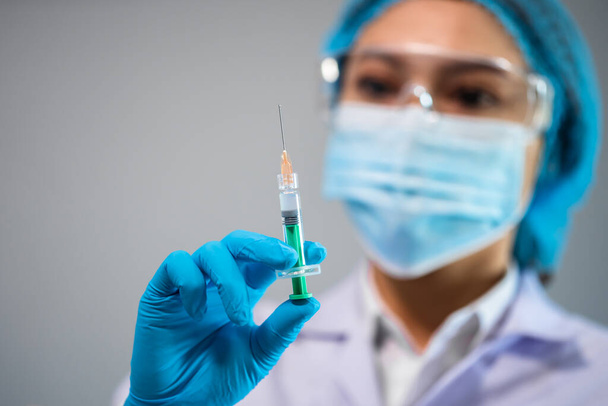 female doctor holding syringe with Coronavirus (Covid-19) vaccine for injection test - Φωτογραφία, εικόνα