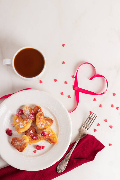 バレンタインデーの朝食。心の形をしたおいしいチーズケーキには、コーヒーアメリカのミルクが入っています。最上階だ。愛の概念.  - 写真・画像