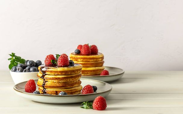 ラズベリー、ブルーベリー、蜂蜜とおいしいアメリカのパンケーキ。コピースペース付きの家族の朝食コンセプト. - 写真・画像