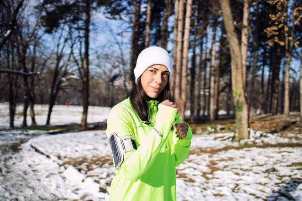 Sportlerin in winterlicher Trainingskleidung im Park. - Foto, Bild