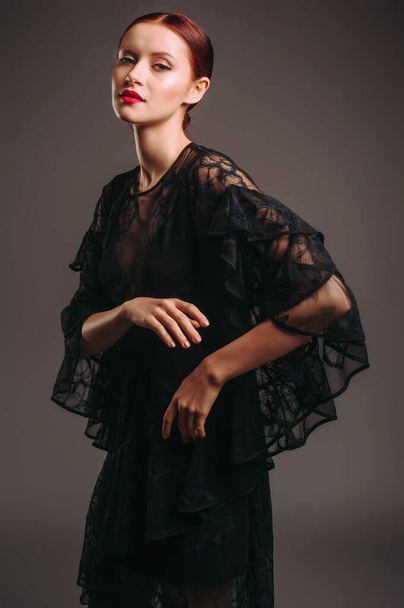 バットスリーブと黒の透明な夜のドレス。ハイヒールを履いた美しいモデル,イベントのための現代的な女性的な外観.女性のファッション。お嬢様. - 写真・画像