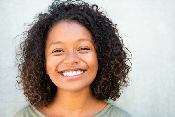 Zblízka horizontální portrét roztomilý afroameričanka s kudrnaté vlasy s úsměvem  - Fotografie, Obrázek