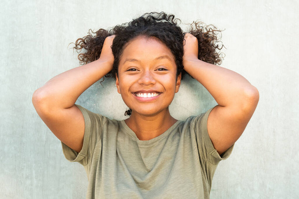 Nahaufnahme Porträt schöne junge Afroamerikanerin macht Zöpfe mit Haaren - Foto, Bild