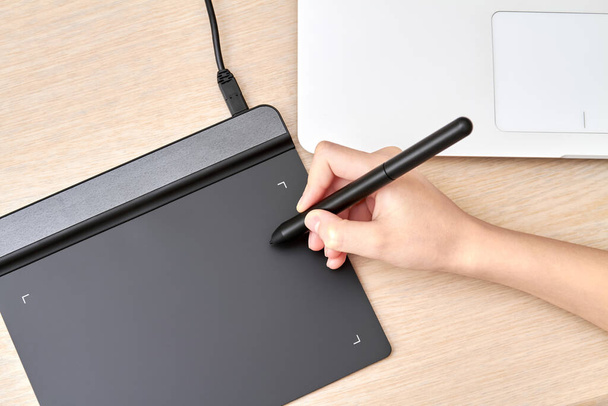 Κορίτσι αντλεί σε ένα tablet γραφικών με στυλό. Κοντινό πλάνο, επιλεκτική εστίαση. - Φωτογραφία, εικόνα