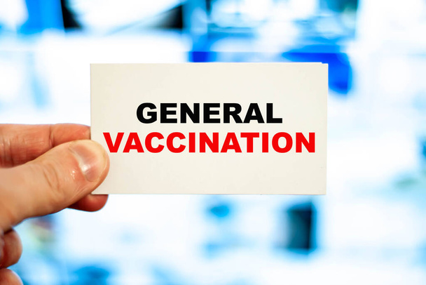 Medical professional holding a business card with GENERAL VACCINATION - Photo, Image