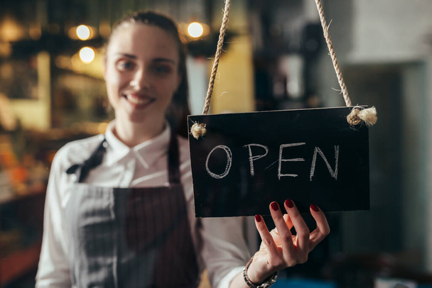 waitress holding open signboard in cafeteria - Photo, image