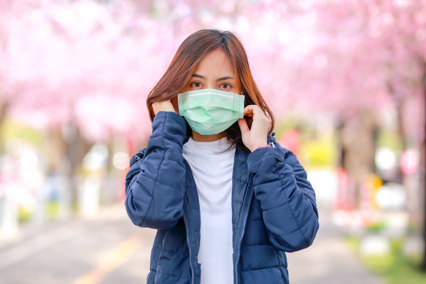 Коронавирус в Японии изображает молодую женщину в хирургической маске для защиты от коронавируса (COVID-19). концепт туристов путешествовать в Азии после эпидемии коронавируса. - Фото, изображение