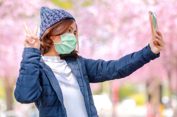 Virus Corona au Japon portrait d'une jeune femme asiatique voyageuse portant un masque chirurgical pour se protéger du virus Corona (COVID-19). concept touristes Voyage en Asie après l'épidémie de coronavirus. - Photo, image