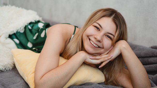 Beautiful smiling blonde in green pajamas. Good morning concept - Photo, image