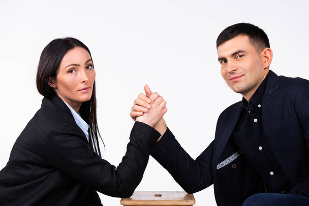 Business partners are competing and looking at the camera. Arm wrestling on a white background. - Fotografie, Obrázek