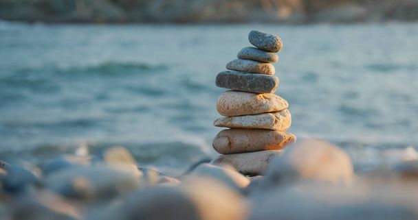 Balanceada piedra de guijarro en la playa al atardecer - Foto, imagen