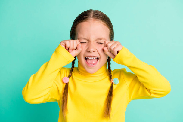 Photo of unhappy sad brown haired little girl cry stressed offended isolated on shine teal color background - Foto, Imagen