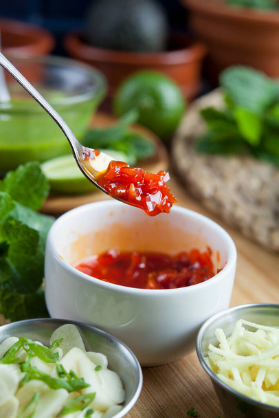 Rode pikante saus - limoen en knoflook rode pikante chili salsa thuis. Saus op de lepel. - Foto, afbeelding