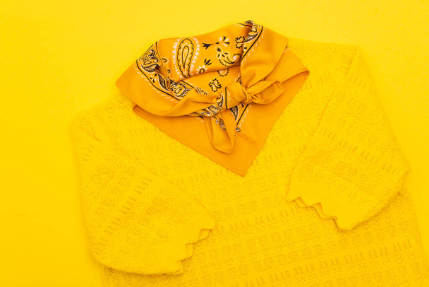 bovenaanzicht van sjaal met sieraad en kleding geïsoleerd op geel  - Foto, afbeelding