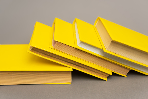 stacked yellow notebooks and books on grey - Photo, Image