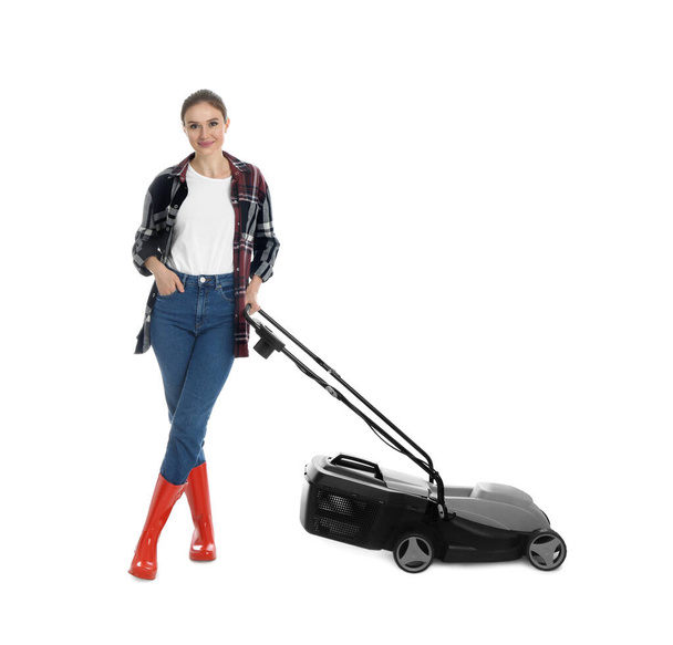 Young woman with modern lawn mower on white background - 写真・画像