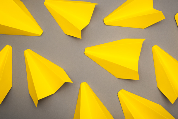 top view of yellow paper planes on grey background - Zdjęcie, obraz