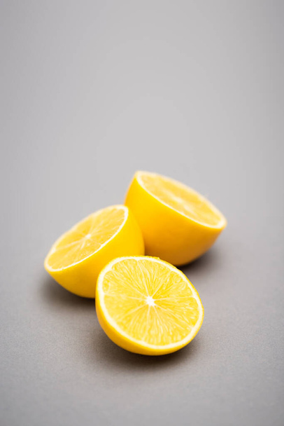 three halves of juicy lemons on grey background  - Foto, immagini
