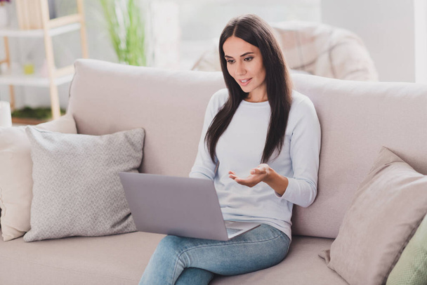 Photo of attractive young woman talk video conference hold laptop freelancer sit couch home inside house - Φωτογραφία, εικόνα