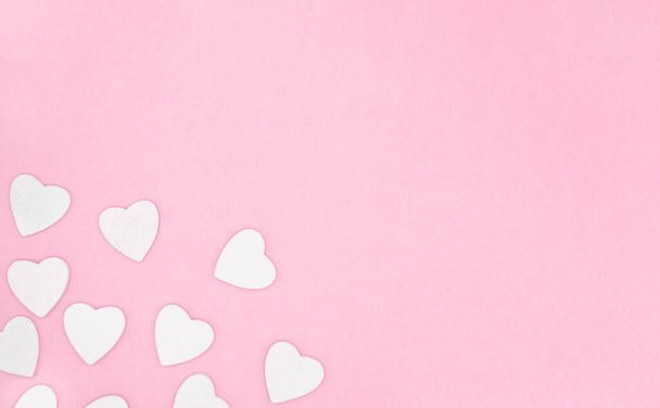 Corazones blancos de madera sobre fondo de color rosa suave, borde, espacio de copia. Concepto de San Valentín para diseño. - Foto, Imagen