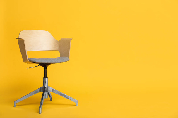 Moderna silla de oficina sobre fondo amarillo. Espacio para texto - Foto, imagen