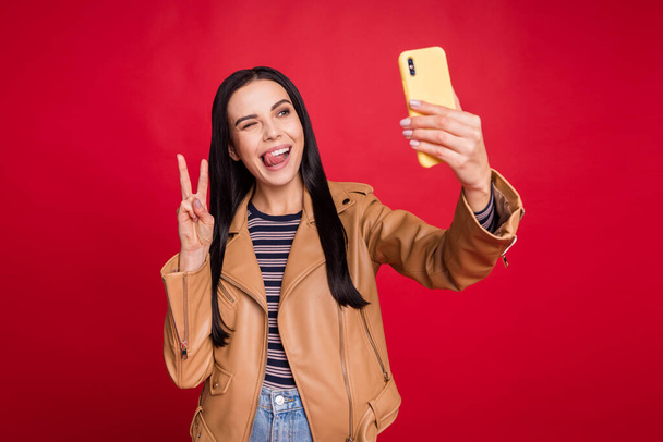 Portrait of funny lady take selfie photo tongue out lick lip show v-sign eye wink isolated on red color background - 写真・画像