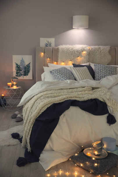 Cozy bedroom interior with warm blanket and cushions - Photo, image