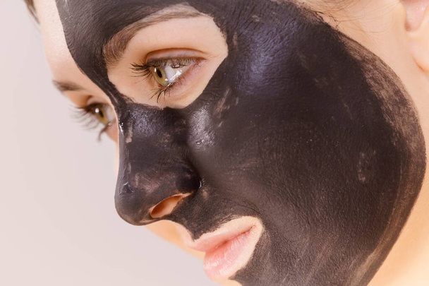 Skin care. Woman with charcoal facial mask, deep cleanser on face. Beauty, spa and acne treatment. Side view - Photo, image