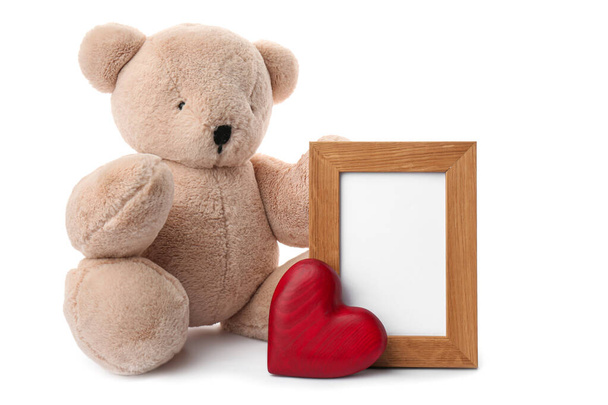 Cute teddy bear with red heart and frame on white background. Valentine's day celebration - Фото, зображення