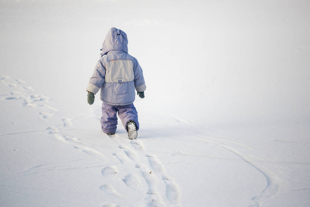 pequeño niño solitario en invierno en el hielo en la nieve 2020 - Foto, imagen