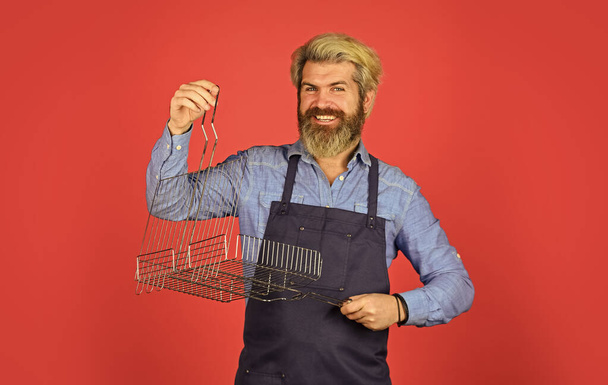 Bbq food. Culinary concept. Tools roasting meat. Man in apron hold barbecue grill. Cooking utensils. Summer picnic. Have fun enjoy cooking. Hipster dyed beard promoting bbq equipment. Cooking healthy - Fotó, kép