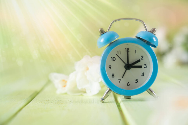 Spring time daylight saving concept - with alarm clock and flowers - Foto, imagen